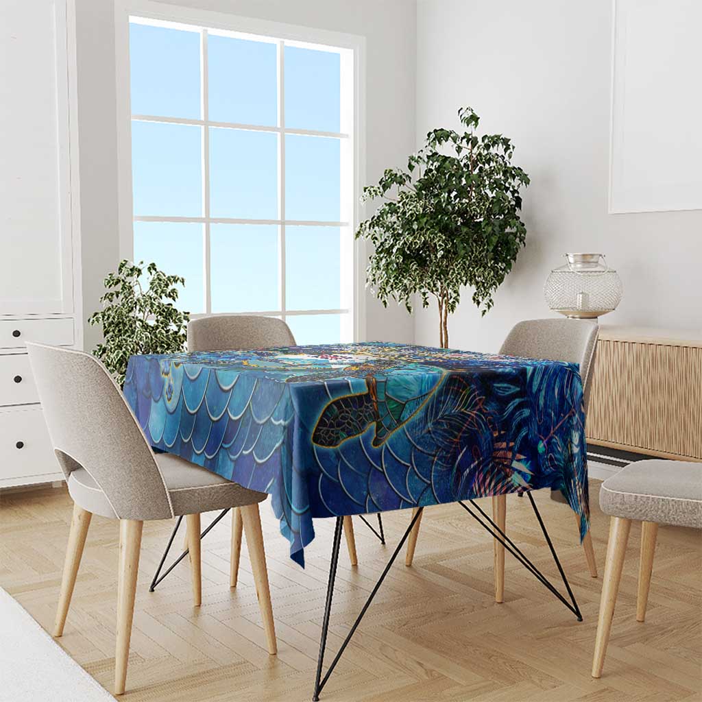 Blue sea turtle tablecloth draped over dining table, scalloped wave edge design.