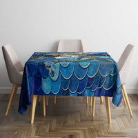 Blue sea turtle tablecloth on dining table with scalloped scale pattern across center.