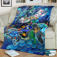 Blue sea turtle tropical blanket draped over sofa, 'Guadeloupe' text and reef turtles