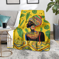 Yellow woman portrait blanket with tropical leaf print and geometric zigzag trim, folded