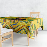 Yellow tropical tablecloth draped over rectangular dining table, blue geometric and leaf motifs