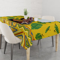 Yellow tropical tablecloth on dining table with blue geometric shapes and green leaf print
