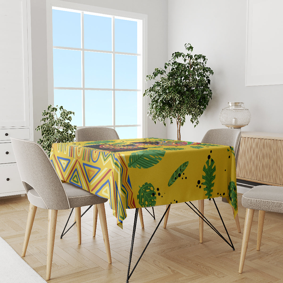 Yellow tropical tablecloth on dining table with blue geometric accents and green leaf pattern