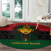 Round pharaoh area rug in red, green, and black with gold face motif and text