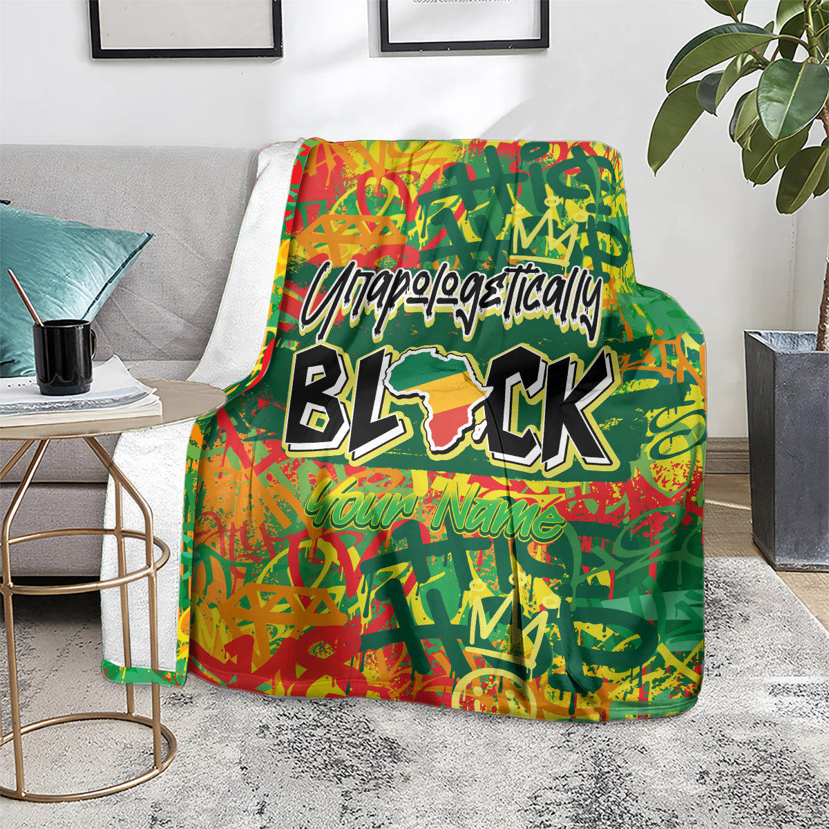 Personalized throw blanket on a sofa chair, green with red-orange street art and black BLK text.