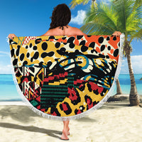 Round beach blanket with fringe edge, multicolor animal pattern, shown unfolded.