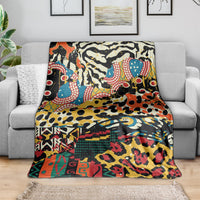 Animal-pattern fleece throw blanket draped on gray sofa, vivid multicolor design.
