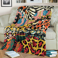 Bright animal-pattern fleece blanket folded on striped sofa cushion, colorful motifs.