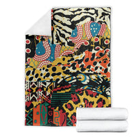 Animal-pattern fleece blanket shown folded with two white towels, bold multicolor print.