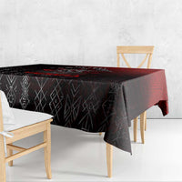 Black tablecloth with geometric rune pattern and red trim, draped over dining table