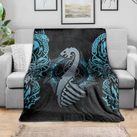 Dragon rune throw blanket draped over sofa, black base with blue teal patterns