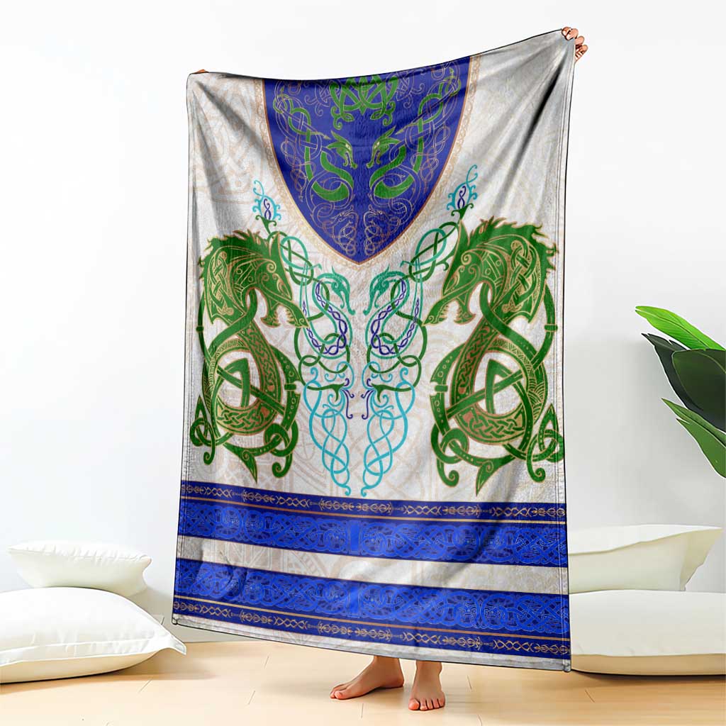 Green and blue celtic knot dragon blanket held up, cream base with blue border