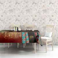 Printed tablecloth with tribal-style border and geometric center, black, teal, and rust with leaf motif