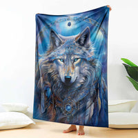 Blue wolf face blanket with circular pendant, held up upright for full view