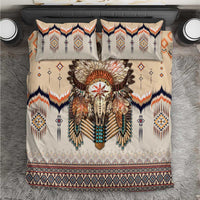 Beige bedding set with feathered skull motif, orange and navy geometric borders, turquoise accents