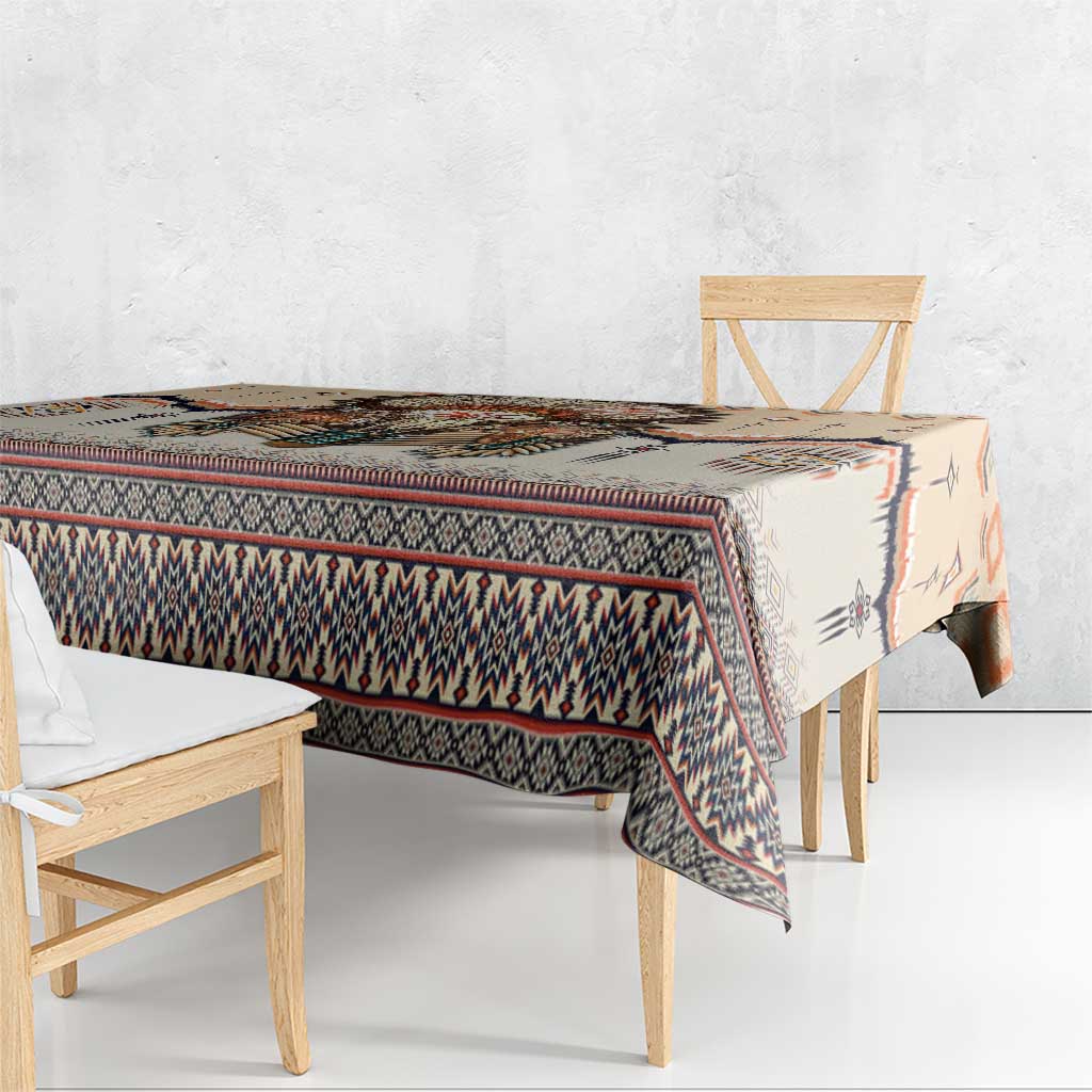 Beige tablecloth draped over table with multicolor Native American geometric border.