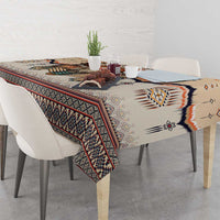 Beige tablecloth with multicolor tribal geometric stripes and central motif on tabletop.