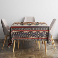 Beige tablecloth with multicolor geometric stripe border on a dining table.