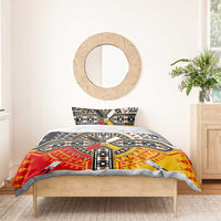 Tribal geometric bedding set featuring black, red, and yellow cross motif on duvet.