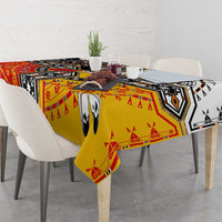 Rectangular Native American tablecloth draped over dining table; bold red, yellow, black pattern