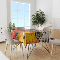 Patterned tablecloth on dining set, featuring red, yellow, black, and white geometric design