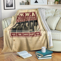 Beige group blanket draped on couch with N.W.A burgundy graphic and portraits