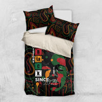 Personalized bedding set laid on bed: dark duvet with portrait graphic and 2 pillowcases