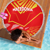 Round red Macedonian flag beach blanket, fringed border, laid flat with corner view