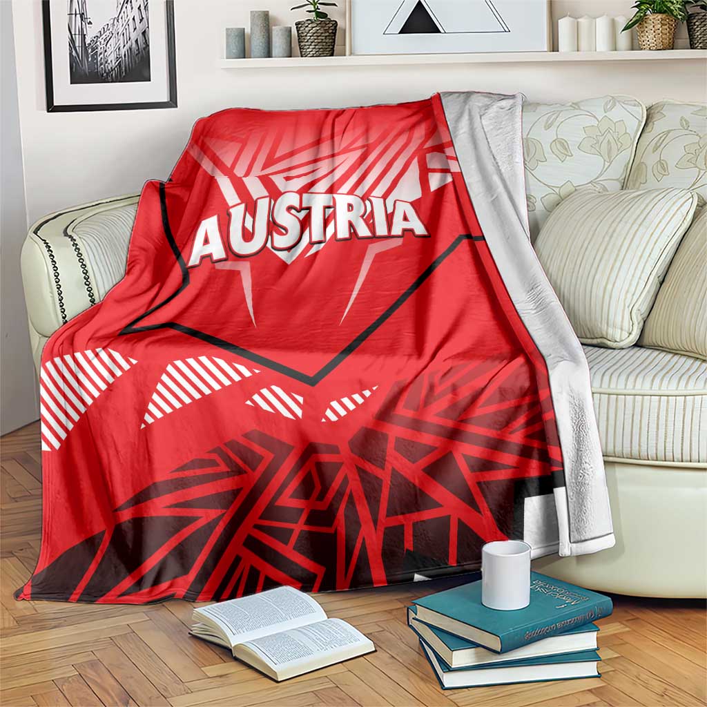 Red throw blanket with white AUSTRIA eagle graphic and gray backing edges