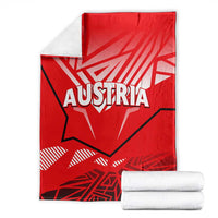 Folded red blanket with white AUSTRIA eagle design and gray backing
