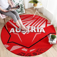 Red round carpet with AUSTRIA lettering and geometric eagle design