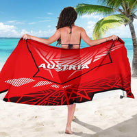 Red sarong with AUSTRIA eagle graphic, held wide across back for a beach cover-up