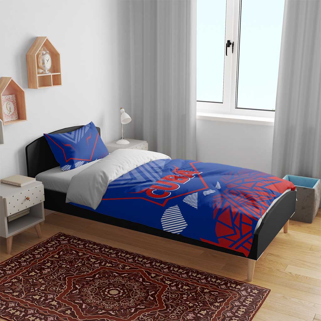 Blue bedding set on bed with "CUBA" print duvet and two matching geometric pillows