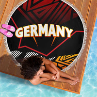 Circular beach blanket with fringed border, Germany text over black and red patterns