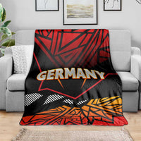 Black, red, and orange Germany graphic blanket laid across a gray sofa