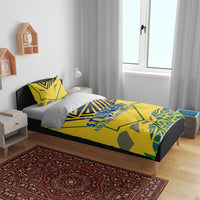 Yellow duvet cover and two pillowcases on a bed, blue-green emblem graphic with text.