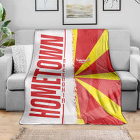 Macedonia flag and map blanket over gray sofa, red/yellow/white graphic