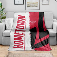 Cuba flag-themed throw blanket with red and black diagonal pattern over gray sofa