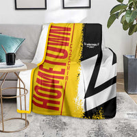 Yellow, red, black and white Germany flag blanket on gray couch, partially draped