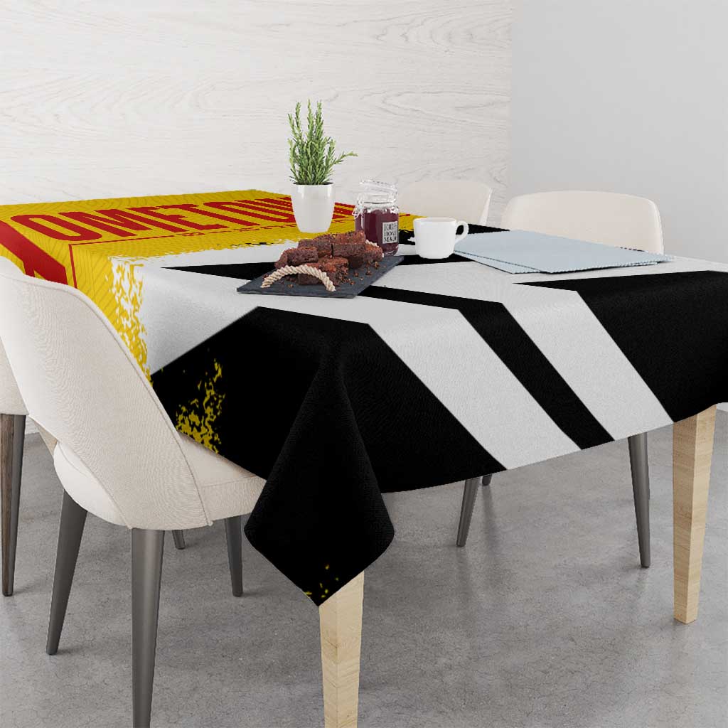 Germany-themed tablecloth on dining table with bold diagonal black-and-white bands and yellow-red section
