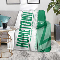 Green and white Nigeria flag and map blanket over sofa, beside side table
