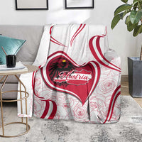 Austria-themed blanket on a couch with red heart emblem, roses, and red wave stripes