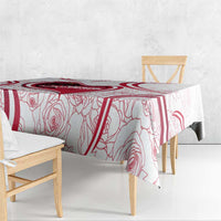 Red and white tablecloth with rose outline and thick stripe border on tabletop
