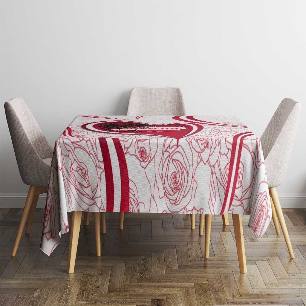 Red and white tablecloth with Austria crest, roses, and red stripe borders on table