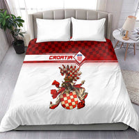 White duvet set with red check top band and large coat-of-arms crest, two pillows