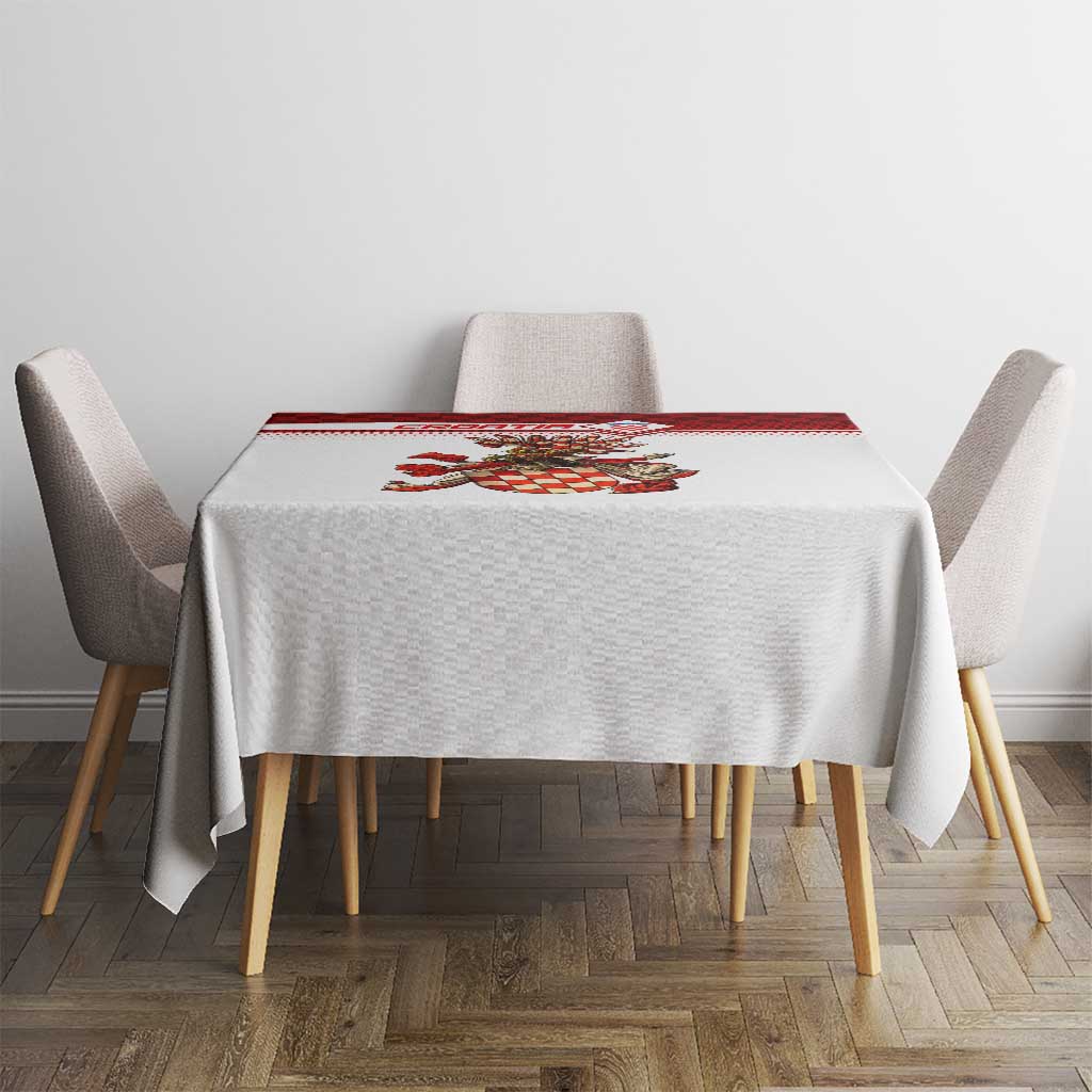 Small square tablecloth with red check border and crest centerpiece, styled on dining set.