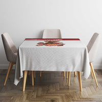 Small square tablecloth with red check border and crest centerpiece, styled on dining set.