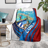 Cuba map blanket with coat of arms shield, blue and red striped design, on gray couch