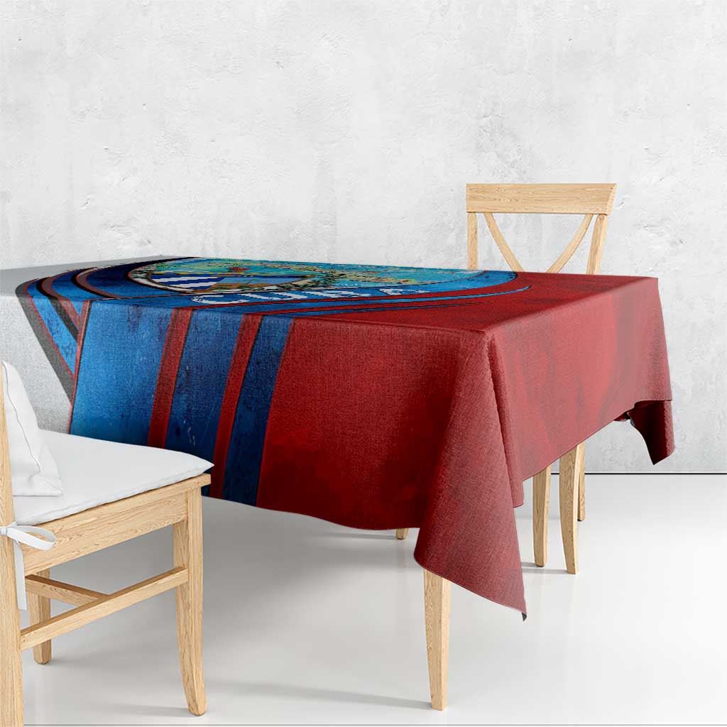 Cuban map and coat of arms tablecloth in red and blue, draped on table.