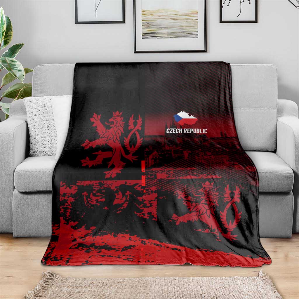 Black and red lion print blanket with 'CZECH REPUBLIC' logo, covering gray sofa